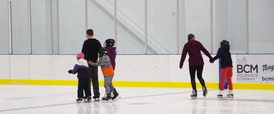 family skating on indoor ice rink