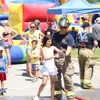 child with firefigher ready to spray fire hose