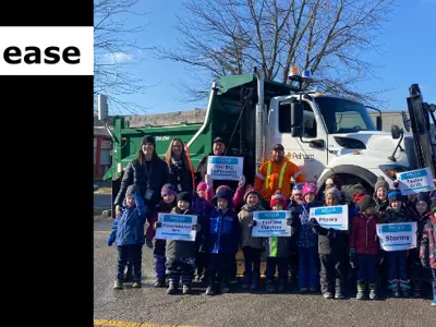 school kids hold signs with plow names infront of a Town of Pelham Plow