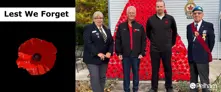 Lest we forget and poppy image with group of veterans receiving a poppy